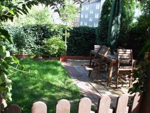 a backyard with a table and chairs and a fence at Lovely Apartment 2 Et Inkl Parkplatz nach Verfügbarkeit in Essen