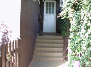 a brick house with a white door and stairs at Lovely Apartment 2 Et Inkl Parkplatz nach Verfügbarkeit in Essen +5 photos