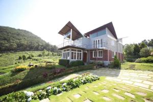 ein Haus mit einem Garten davor in der Unterkunft DWELLINGTON in Kotagiri