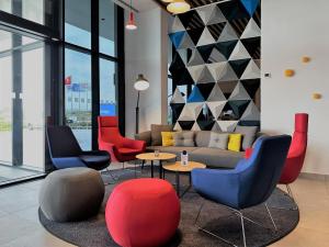 a living room with chairs and a couch and tables at Holiday Inn Express - Ankara - Airport by IHG in Ankara