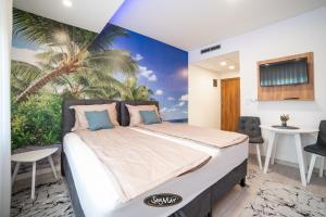 a bedroom with a bed with a palm tree mural at San-Mar Apartments in Tuzla