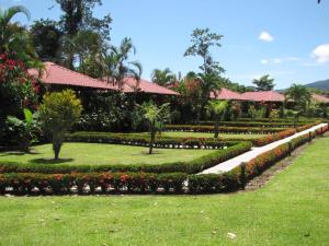 Un jardín frente a un resort con flores. en Hotel La Pradera del Arenal, en Fortuna