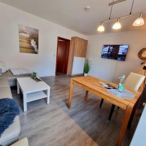 sala de estar con mesa y sofá en Ferienwohnung und Appartementvermietung Haus-Kaiser, en Büsum