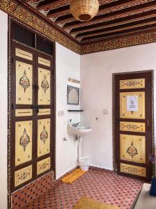 a bathroom with two doors and a sink at Hostel Kech Vibe in Marrakesh