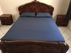 a large bed with a wooden frame and blue sheets at Appartement spacieux à Agadir in Agadir +21 photos