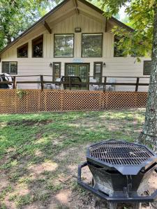 a grill in front of a building with a tree at Hideaway - 3 BR Home with PRIVATE POOL on wooded lot in Montgomery