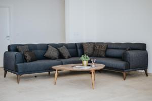 a blue couch and a coffee table in a room at MonteCasa Seaview Rooms in Dobra Voda