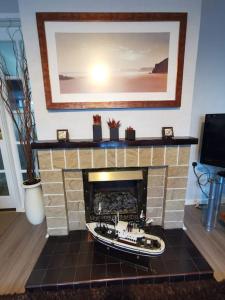 a brick fireplace with a boat on top of it at Ballywalter Beach House in Ballywalter
