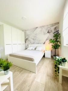 - une chambre avec un lit et des plantes dans l'établissement Anapartments, à Primošten