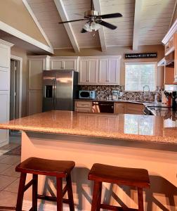 a kitchen with a large counter with two stools at Hideaway - 3 BR Home with PRIVATE POOL on wooded lot in Montgomery