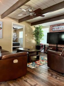 a living room with a couch and a flat screen tv at Hideaway - 3 BR Home with PRIVATE POOL on wooded lot in Montgomery