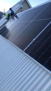 Um homem num telhado com painéis solares. em Clarence House em Cidade do Cabo