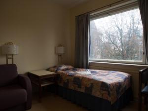 um quarto com uma cama, uma janela e uma cadeira em Laitilan Kievari em Laitila