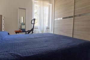 um quarto com uma cama azul e uma janela em Estate em Desenzano del Garda