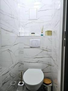 a white toilet in a bathroom with marble walls at ParkHome in Stalowa Wola