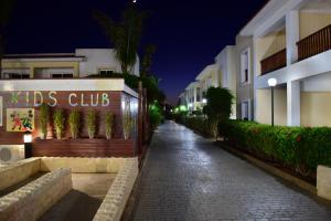 a street at night with aalks club sign on a building at Aktea Beach Village in Ayia Napa