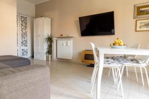 a living room with a white table and a tv at Estate in Desenzano del Garda