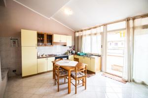 une cuisine avec une table en bois et des placards jaunes dans l'établissement Stella Marina siderno, à Siderno Marina