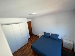 um quarto com uma cama azul e armários brancos em Playa Compostela em Vilagarcía de Arousa