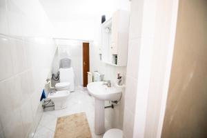 La salle de bains blanche est pourvue d'un lavabo et de toilettes. dans l'établissement Stella Marina siderno, à Siderno Marina