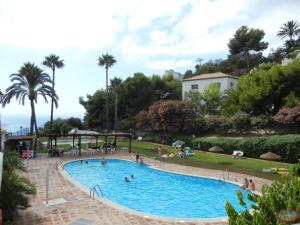 basen w ośrodku z osobami w nim w obiekcie La Torrecica, con carácter andaluz y magníficas vistas al mar y Sierra Nevada w mieście Salobreña