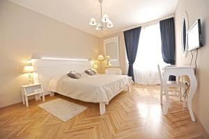 um quarto com uma cama branca e piso em madeira em Tinel Rooms Old City Center em Zadar