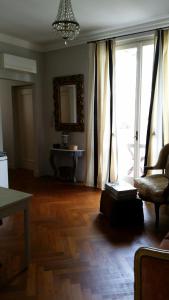 un soggiorno con pavimento in legno, sedia e finestra di Cavour 45 a Vittuone