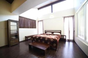 ein Schlafzimmer mit einem Bett und einem großen Fenster in der Unterkunft DWELLINGTON in Kotagiri