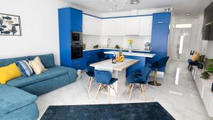 Il dispose d'une cuisine bleue et d'un salon avec un canapé bleu. dans l'établissement River&Lake Luxury I. Apartman, à Sárvár