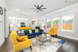 a living room with yellow chairs and a blue couch at Spectacular 4BRs Home in Downtown Dallas in Dallas