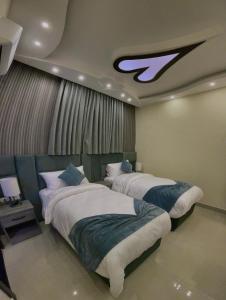 two beds in a hotel room with avertisement at Fragrant Rose in Wadi Musa