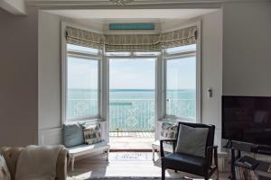 a living room with a large window with a view of the ocean at Seagulls by Bloom Stays in Folkestone