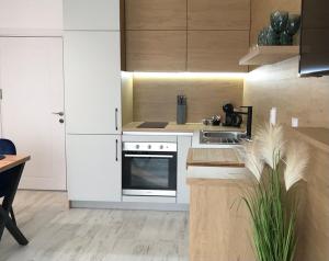 a kitchen with white cabinets and a sink and a stove at Аpartment Bella Vista in Obzor
