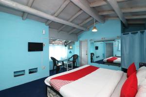 ラニケートにあるOYO 27772 Hotel Kalawati Retreatのベッドルーム1室(ベッド1台、テーブル、椅子付)
