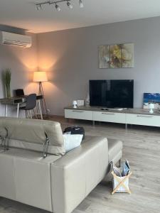 a living room with a white couch and a flat screen tv at Green Hill Penthouse apartment in Korčula