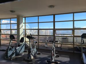 un gimnasio con bicicletas en una habitación con ventanas en Departamento Santa Lucía, en Santiago