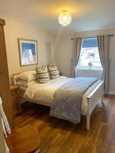 1 dormitorio con cama con almohadas y ventana en One Abbey Court en Whitby