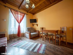 - un salon avec une table, une chaise et une fenêtre dans l'établissement Pensiunea Flora, à Băile Tuşnad