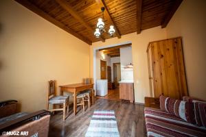 uma sala de estar com uma mesa de jantar e cadeiras em Pensiunea Flora em Băile Tuşnad