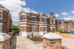 a large brick house with a courtyard in front of it at Park Lake View in Poole