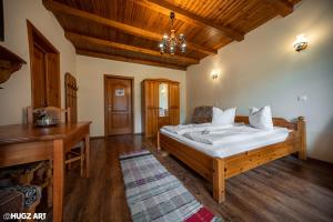 1 dormitorio con cama y techo de madera en Pensiunea Flora en Băile Tuşnad
