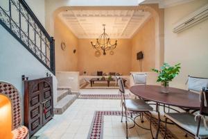 een eetkamer met een tafel en een kroonluchter bij Riad Résidence Al Qaria Assiyahia Riad 22 in Marrakesh