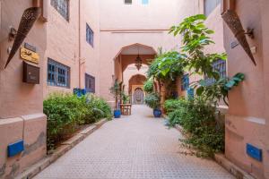een steegje in een oud gebouw met planten bij Riad Résidence Al Qaria Assiyahia Riad 22 in Marrakesh