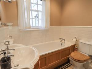 a bathroom with a tub and a toilet and a sink at Grisedale View in Keswick +20 photos