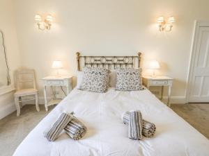 a bedroom with a white bed with two tables at Grisedale View in Keswick