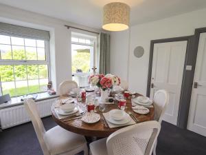 a dining room with a wooden table and chairs at Greenstyles in Bowness-on-Windermere