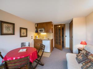 a living room with a table and a kitchen at Studio Megève, 1 pièce, 4 personnes - FR-1-453-73 in Megève