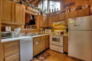 kuchnia z drewnianymi szafkami i białymi urządzeniami w obiekcie Apple Bear View #116 w mieście Sevierville