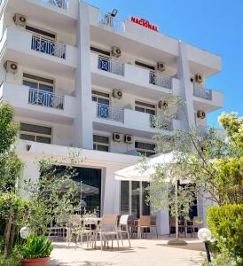 uma vista exterior de um hotel com mesas e cadeiras em Hotel Nacional Durres em Durrës