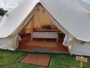 a tent with a bed inside of it at Chestnut Luxury emperor bell tent with log burner in Liverton